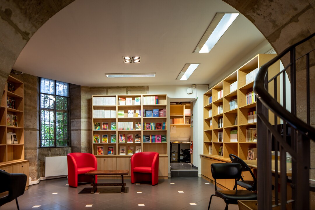 Photo de l'intérieur de la librairie des Éditions de la Sorbonne, avec des étagères de livres et un espace rencontres pourvu de deux fauteuils